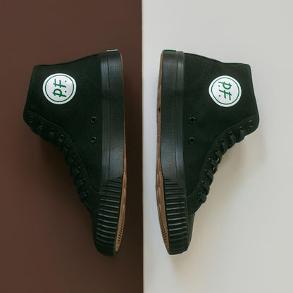 Black high-top sneakers with the green P.F. Flyers logo on a brown and white background