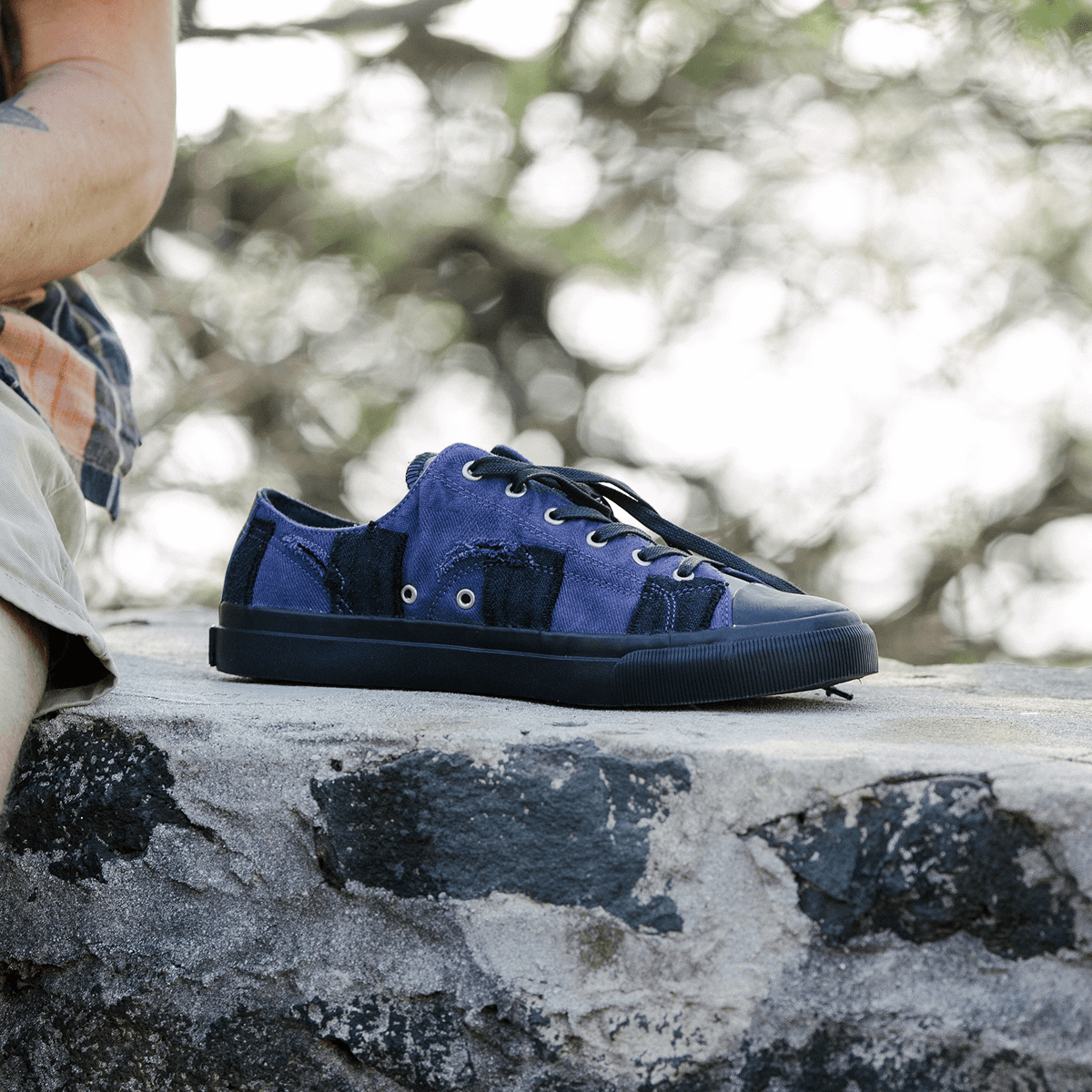 Blue sneakers on a stone surface with a blurred natural background