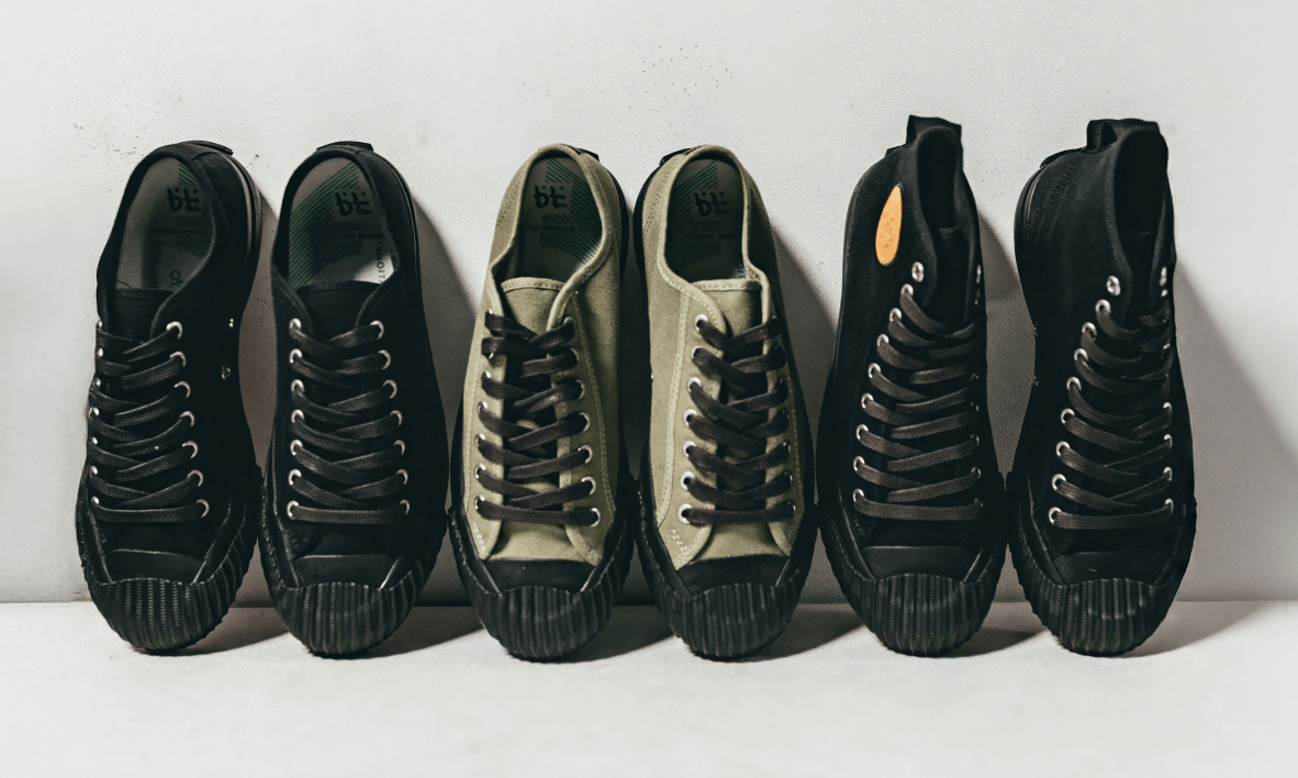 Two pairs of black canvas sneakers and one pair of olive green sneakers on a white background.